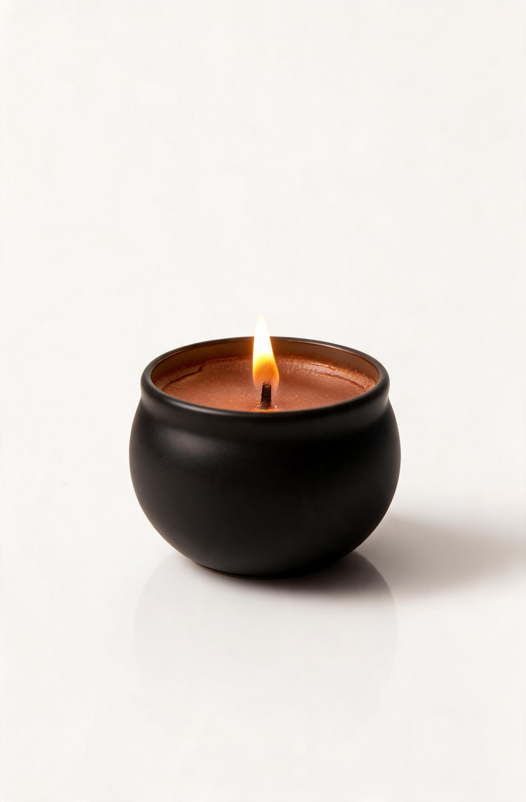 Rawmantic chocolate scented candle lit in a round black pot